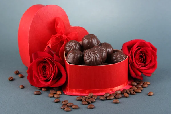 Шоколадні цукерки в подарунковій коробці, на сірому фоні — стокове фото