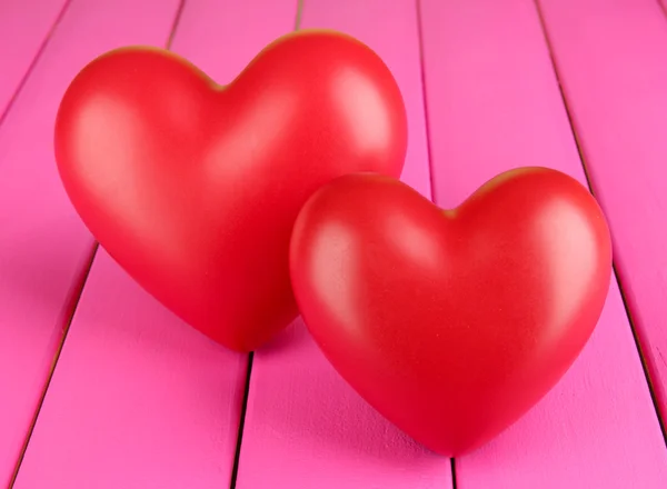 Decorative red hearts on color wooden background — Stock Photo, Image