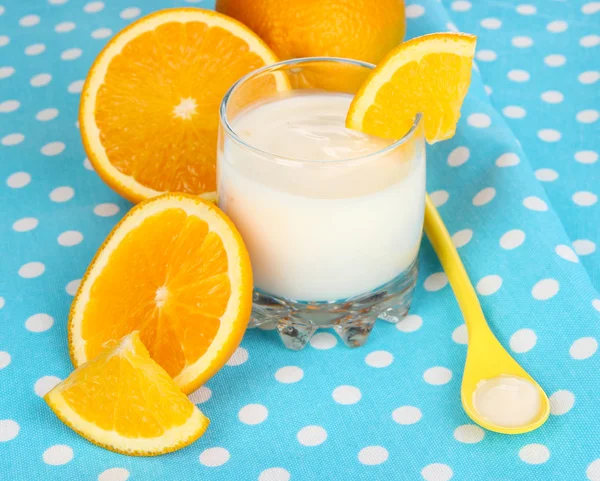 Glass of yougyrt and oranges on naprin — Stock Photo, Image