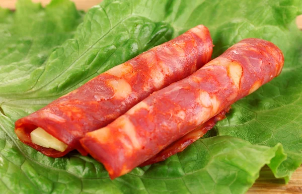 Salami rolls on wooden board, close up — Stock Photo, Image