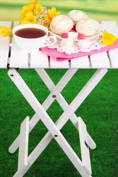 Schöne Komposition mit einer Tasse Tee und Marshmallow auf einem hölzernen Picknicktisch auf natürlichem Hintergrund — Stockfoto