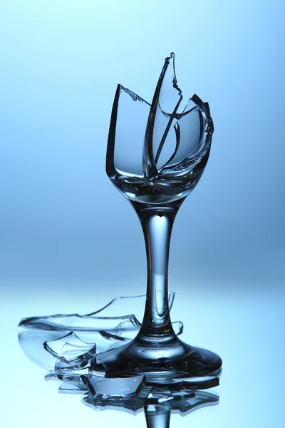 Gebroken wijnglas op blauwe achtergrond — Stockfoto