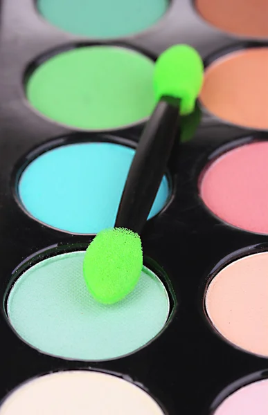 Bright eye shadows and sponge brush for foundation close up — Stock Photo, Image