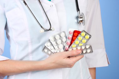 kadın doktor el hapları, renkli arka plan üzerinde tutarak yakın çekim