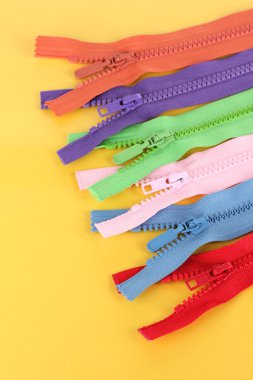 sarı arka plan üzerinde renkli fermuarlar