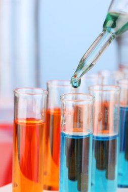 Laboratuvar pipet renkli sıvı cam test tüpleri üzerinde damla ile yakın çekim