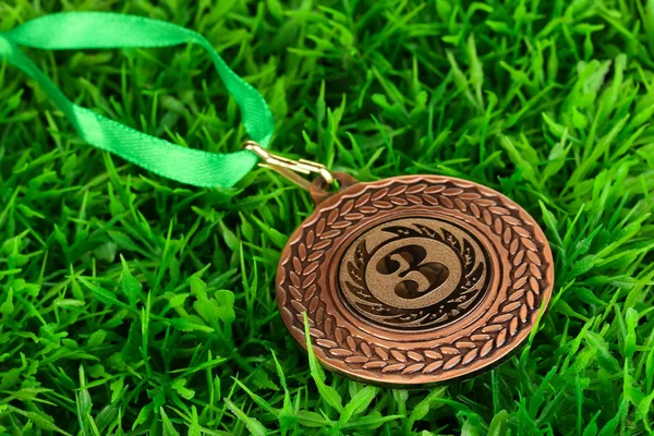 Бронзовая медаль на фоне травы — стоковое фото