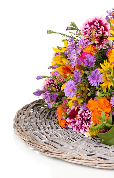 Beautiful bouquet of bright flowers on wicker mat isolated on white — Stock Photo, Image