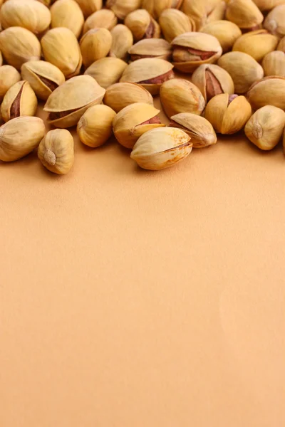 Sabrosas nueces de pistacho, sobre fondo beige —  Fotos de Stock