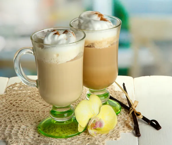 Fragrant coffee latte in glasses cups with spices, on wooden table — Stock Photo, Image