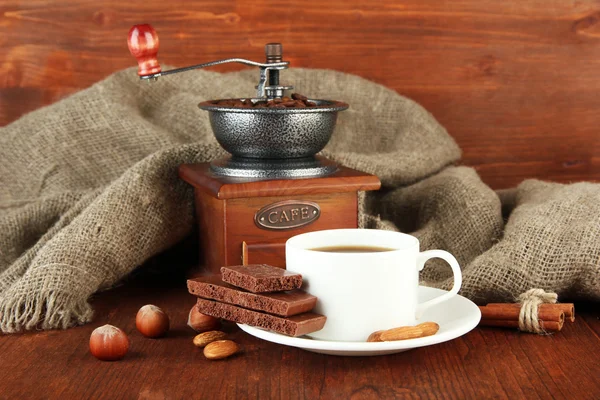 Mörk choklad, varm dryck och kaffe kvarn på trä bakgrund — Stockfoto