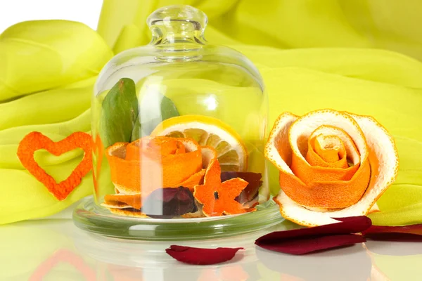 Decorative rose from dry orange peel in glass vase on green fabric background — Stock Photo, Image