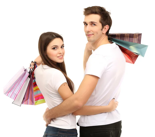 Joven pareja de compras y la celebración de muchas bolsas de compras aisladas en blanco — Foto de Stock