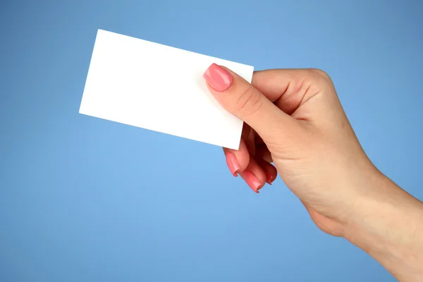 Женщина держит визитную карточку, на цветном фоне — стоковое фото