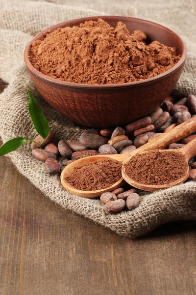 Poudre de cacao et fèves de cacao sur fond en bois — Photo