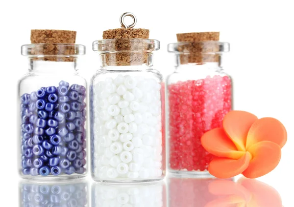 Piccole bottiglie piene di perline colorate isolate su bianco — Foto Stock
