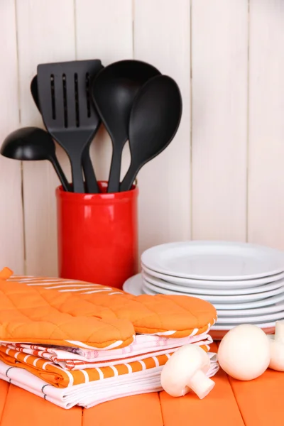 Ajustes de cocina: utensilios, agarraderas, toallas y más en la mesa de madera —  Fotos de Stock