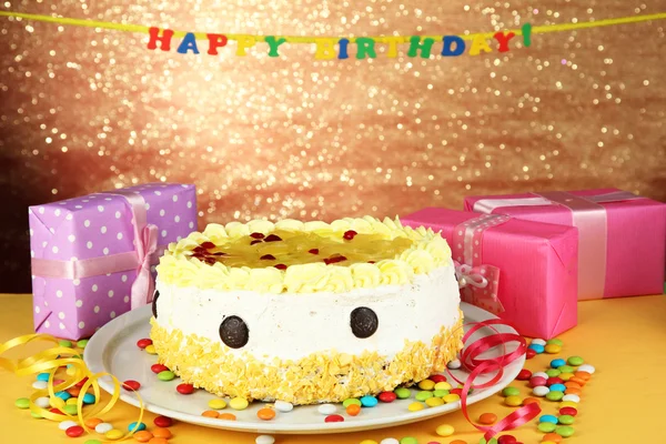 Happy birthday cake and gifts, on bright background — Stock Photo, Image