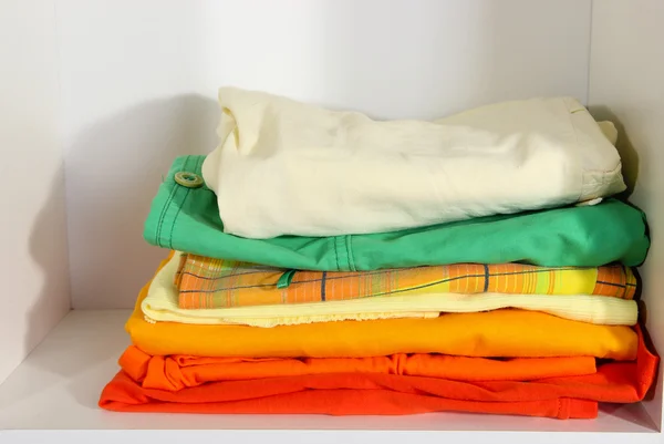 Clothes neatly folded on shelves — Stock Photo, Image