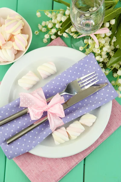 De instelling van de tabel in violette en roze tonen op een houten achtergrond kleur — Stockfoto