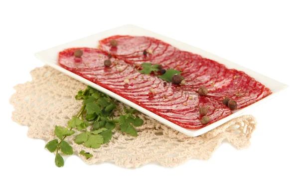Leckere Salami auf Teller auf Serviette isoliert auf Weiß — Stockfoto