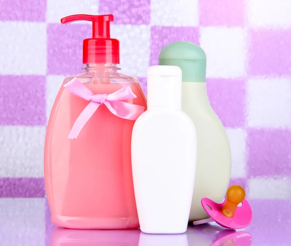 婴儿化妆品在浴室上紫平铺背景墙 — 图库照片