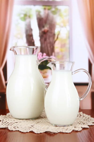 Jarros de leite na mesa no quarto — Fotografia de Stock