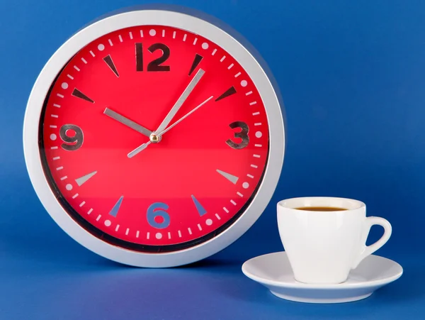 Cup coffee and clock on blue background — Stock Photo, Image