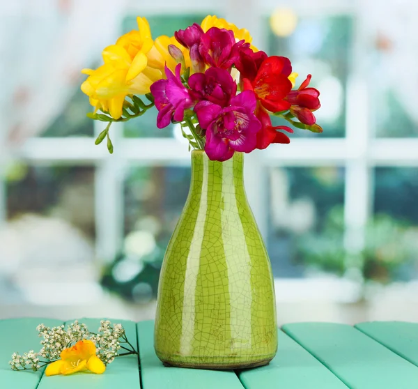 Beau bouquet de freesia en vase jaune sur table en bois sur fond de fenêtre — Photo