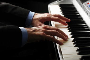 man hands playing piano