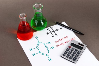 test tüpleri ile renkli sıvılar ve formüllerini gri arka plan üzerinde