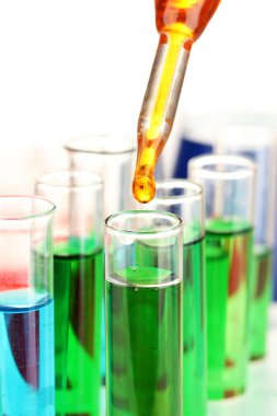 Laboratuvar pipet renkli sıvı cam test tüpleri üzerinde damla ile yakın çekim, üzerinde beyaz izole