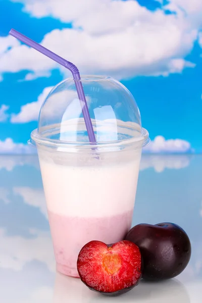 Delicious milk shake with fruit on table on sky background — Stock Photo, Image