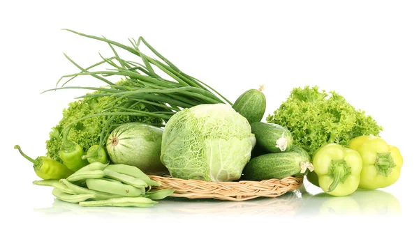 Verse groene groenten op rieten mat geïsoleerd op wit — Stockfoto