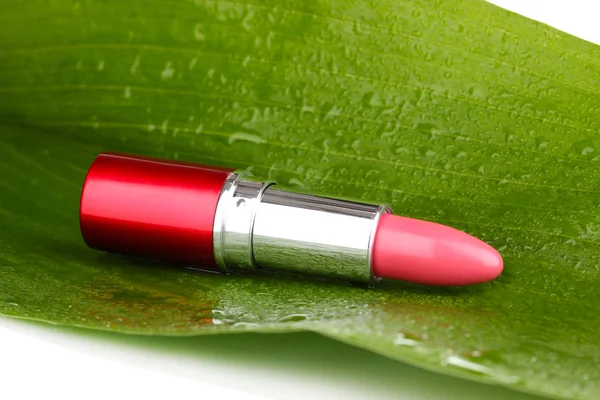 Lápiz labial sobre hoja verde aislado sobre blanco — Foto de Stock