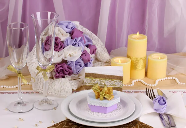 Serverer fabelaktig bryllupsbord i lilla og gull farge på hvit og lilla stoffbakgrunn – stockfoto