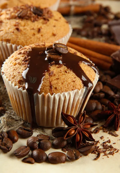 Tasty muffin cakes with chocolate, spices and coffee seeds, close up — Zdjęcie stockowe