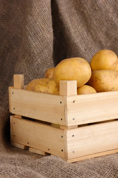 Las patatas maduras en la caja de madera sobre el saqueo —  Fotos de Stock
