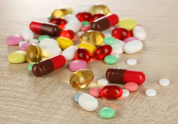 Assortment of pills, tablets and capsules on wooden table — Stock Photo, Image