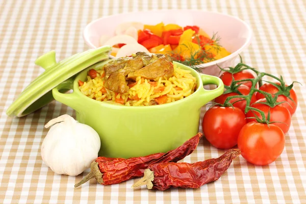 Delicious pilaf with vegetables on tablecloth background — Stock Photo, Image