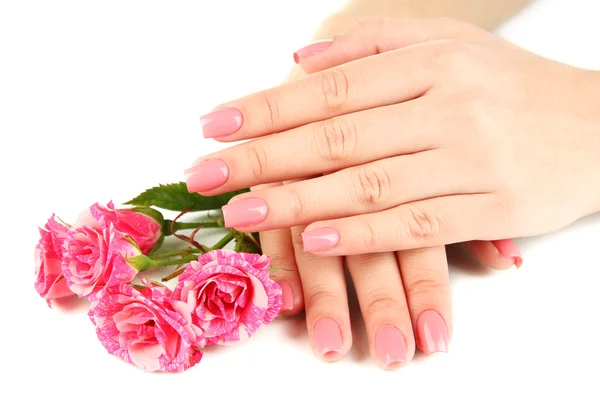 Vrouw handen met roze manicure en bloemen, geïsoleerd op wit — Stockfoto