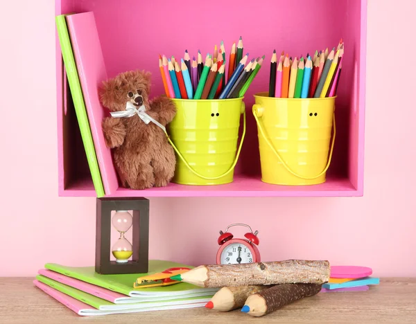 Lápis coloridos em pails na prateleira no fundo bege — Fotografia de Stock