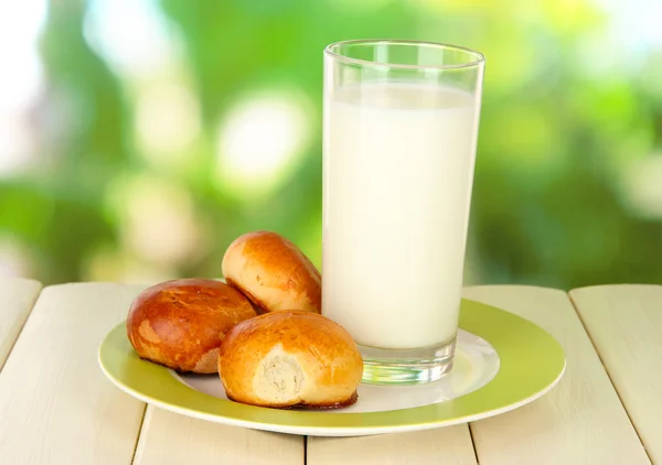 面包卷和牛奶自然背景上的木桌上的玻璃 — 图库照片