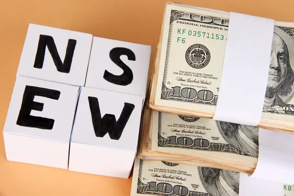 White paper cubes labeled "News" with money on beige background — Stock Photo, Image