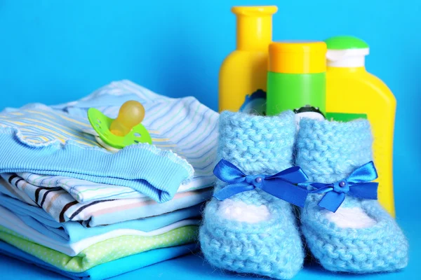 Pile de vêtements de bébé sur fond bleu — Photo