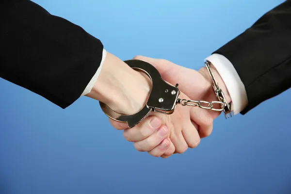 Man and woman hands and breaking handcuffs on color background — Stock Photo, Image