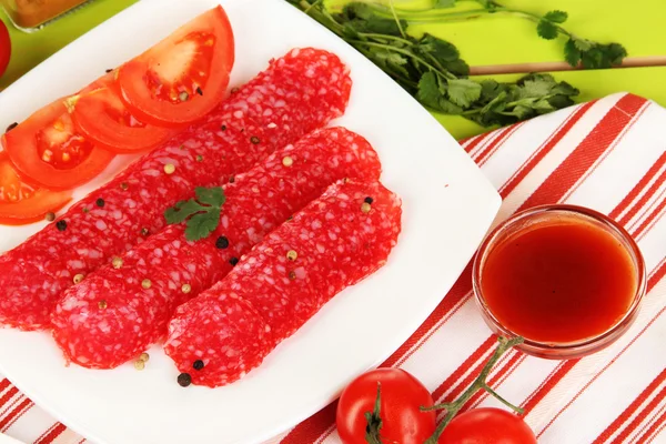 Leckere Salami auf Teller auf Holztisch in Großaufnahme — Stockfoto