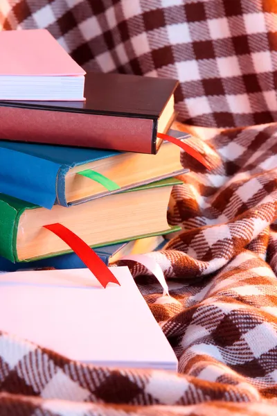 Veel boeken met bladwijzers op plaid — Stockfoto