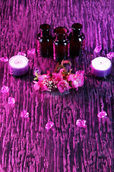 Спа-масло и фрезия на фиолетовом фоне — стоковое фото