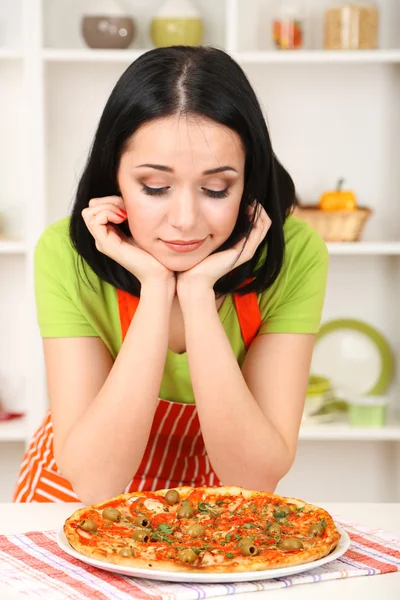 Chica ama de casa con deliciosa pizza en fondo de cocina — Foto de Stock